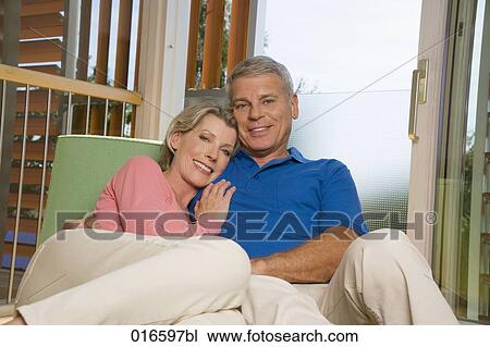 portrait of mature couple sitting on sofa at home View Large Photo Image Stock Image - portrait of mature couple sitting on sofa at home. Fotosearch