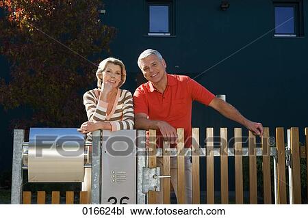 portrait of mature couple standing at garden fence of their home View Large Photo Image Stock Image - portrait of mature couple standing at garden fence of their home. Fotosearch