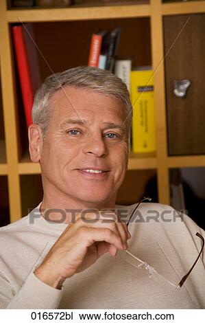 portrait of mature man holding spectacles View Large Photo Image Stock Image - portrait of mature man holding spectacles. Fotosearch