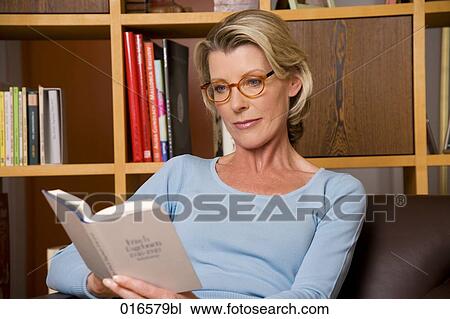 Stock Image - portrait of mature woman reading a book. Fotosearch