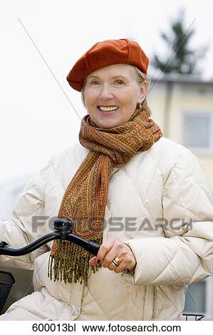 portrait of mature woman wearing beret and holding bicycle View Large Photo Image Stock Image - portrait of mature woman wearing beret and holding bicycle. Fotosearch