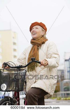 portrait of mature woman wearing beret and holding bicycle View Large Photo Image Stock Image - portrait of mature woman wearing beret and holding bicycle. Fotosearch