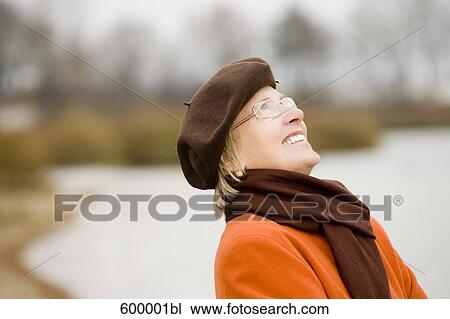 portrait of mature woman wearing brown beret standing at lake in park View Large Photo Image Stock Image - portrait of mature woman wearing brown beret standing at lake in park. Fotosearch