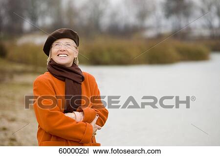 portrait of mature woman wearing brown beret standing at lake in park View Large Photo Image Stock Image - portrait of mature woman wearing brown beret standing at lake in park. Fotosearch