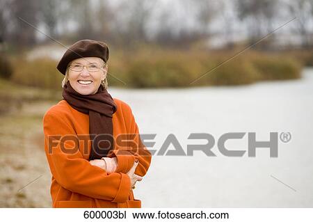 portrait of mature woman wearing brown beret standing at lake in park View Large Photo Image Stock Image - portrait of mature woman wearing brown beret standing at lake in park. Fotosearch