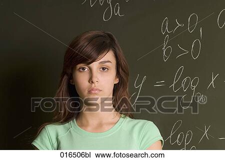 Stock Image - portrait of serious female student in front of blackboard. Fotosearch