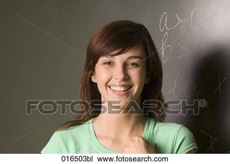 portrait of smiling female student in front of blackboard View Large Photo Image Stock Image - portrait of smiling female student in front of blackboard. Fotosearch