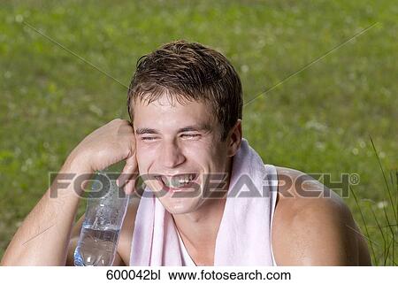 portrait of smiling young man holding water bottle View Large Photo Image Stock Image - portrait of smiling young man holding water bottle. Fotosearch