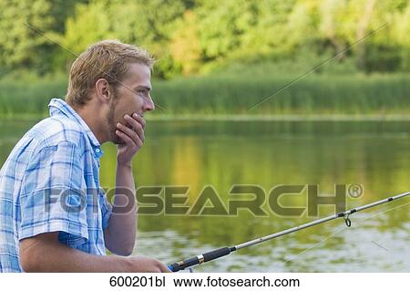 portrait of yawning man holding fishing rod View Large Photo Image Stock Image - portrait of yawning man holding fishing rod. Fotosearch
