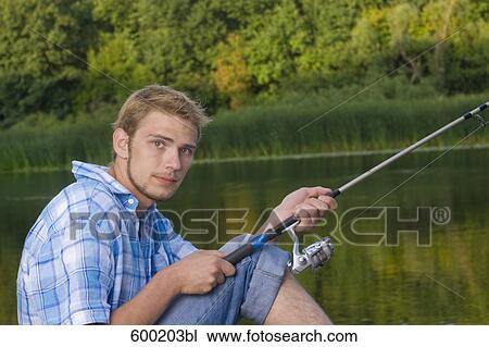 Stock Image - portrait of young man fishing. Fotosearch
