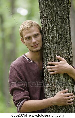 portrait of young man hugging tree View Large Photo Image Stock Image - portrait of young man hugging tree. Fotosearch