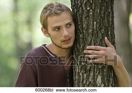 portrait of young man hugging tree View Large Photo Image Stock Image - portrait of young man hugging tree. Fotosearch