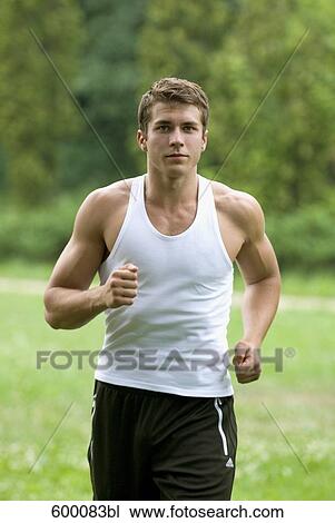 portrait of young man jogging through park View Large Photo Image Stock Image - portrait of young man jogging through park. Fotosearch