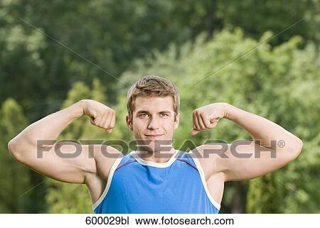 portrait of young man showing his biceps View Large Photo Image Stock Image - portrait of young man showing his biceps. Fotosearch