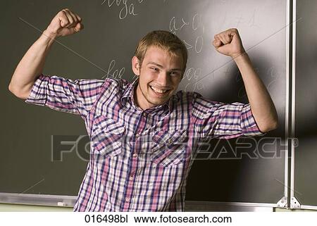 portrait of young student celebrating in front of blackboard View Large Photo Image Stock Image - portrait of young student celebrating in front of blackboard. Fotosearch