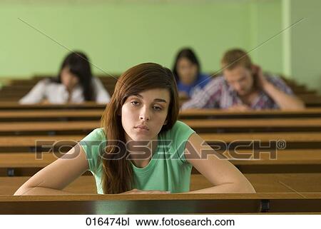 Stock Image - portrait of young student in lecture hall looking bored. Fotosearch