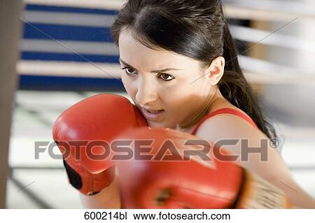Stock Image - portrait of young woman boxing. Fotosearch