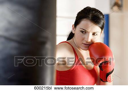 Stock Image - portrait of young woman doing boxing training. Fotosearch
