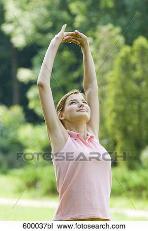portrait of young woman doing stretching exercise in park View Large Photo Image Stock Image - portrait of young woman doing stretching exercise in park. Fotosearch