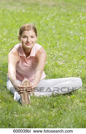 portrait of young woman doing stretching exercise in park View Large Photo Image Stock Image - portrait of young woman doing stretching exercise in park. Fotosearch