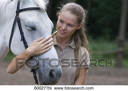 portrait of young woman stroking white horse View Large Photo Image Stock Image - portrait of young woman stroking white horse. Fotosearch