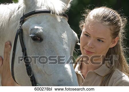 portrait of young woman stroking white horse View Large Photo Image Stock Image - portrait of young woman stroking white horse. Fotosearch