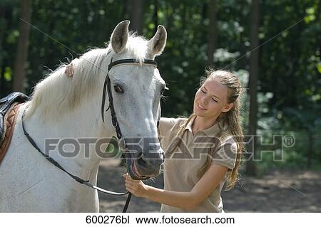 Stock Image - portrait of young woman with white horse. Fotosearch
