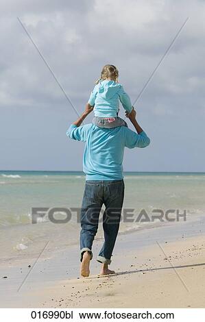 rear view of grandfather man carrying young girl piggyback on beach View Large Photo Image Stock Image - rear view of grandfather man carrying young girl piggyback on beach. Fotosearch