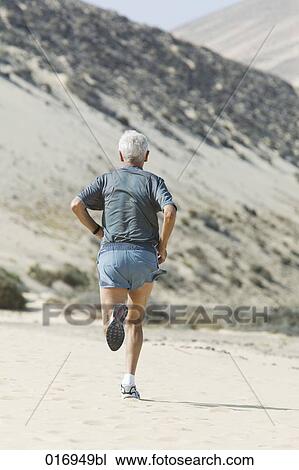 rear view of mature man running on sandy beach View Large Photo Image Stock Image - rear view of mature man running on sandy beach. Fotosearch