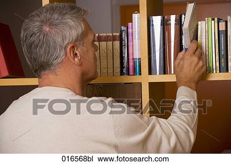 rear view of mature man taking book from shelf View Large Photo Image Stock Image - rear view of mature man taking book from shelf. Fotosearch