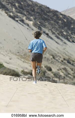 rear view of mature woman running on sandy beach View Large Photo Image Stock Image - rear view of mature woman running on sandy beach. Fotosearch