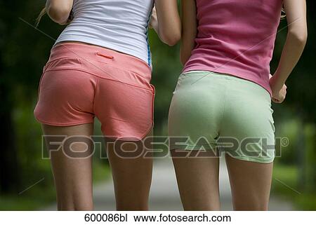 Stock Image - rear view of two young women in sportswear. Fotosearch
