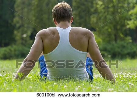 rear view of young man sitting on lawn in park View Large Photo Image Stock Image - rear view of young man sitting on lawn in park. Fotosearch