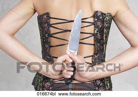 rear view of young woman hiding big knife behind her back View Large Photo Image Stock Image - rear view of young woman hiding big knife behind her back. Fotosearch