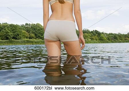 rear view of young woman standing in water in summer View Large Photo Image Stock Image - rear view of young woman standing in water in summer. Fotosearch