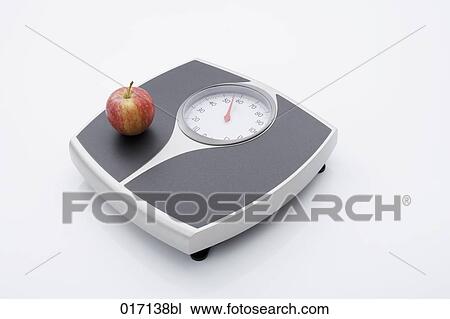 Stock Image - still life of apple on scales. Fotosearch