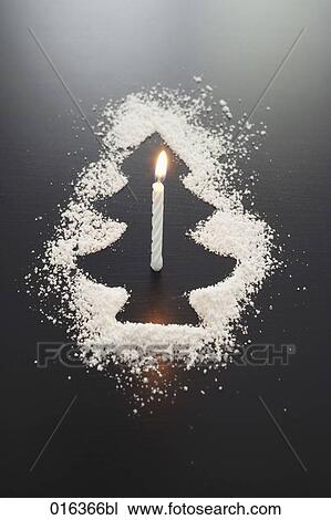 Stock Image - still life of shape of christmas tree made of icing sugar with burning candle. Fotosearch