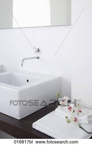 Stock Image - still life of sink in bathroom and orchids. Fotosearch