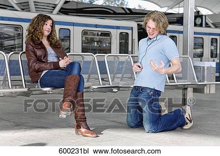 teenage boy playing air guitar in front of girl at underground station View Large Photo Image Stock Image - teenage boy playing air guitar in front of girl at underground station. Fotosearch