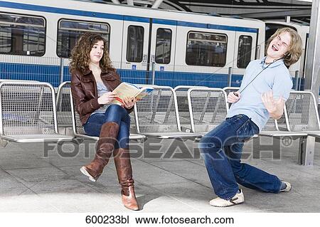 teenage boy playing air guitar in front of girl at underground station View Large Photo Image Stock Image - teenage boy playing air guitar in front of girl at underground station. Fotosearch