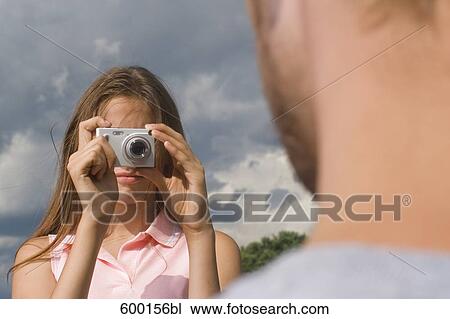 teenage girl taking picture of boyfriend with digital camera View Large Photo Image Stock Image - teenage girl taking picture of boyfriend with digital camera. Fotosearch