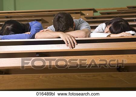 Stock Image - three young students dozing in lecture hall. Fotosearch