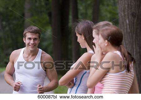 three young woman admiring sporty young man View Large Photo Image Stock Image - three young woman admiring sporty young man. Fotosearch
