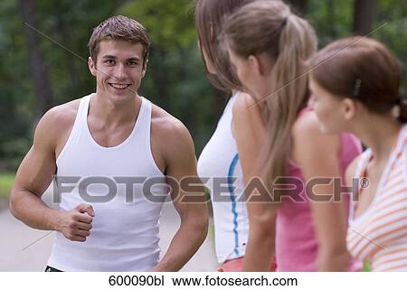 three young woman admiring sporty young man View Large Photo Image Stock Image - three young woman admiring sporty young man. Fotosearch