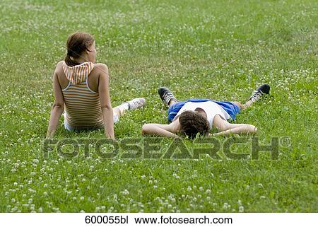 young couple sitting and lying on lawn in park together View Large Photo Image Stock Image - young couple sitting and lying on lawn in park together. Fotosearch