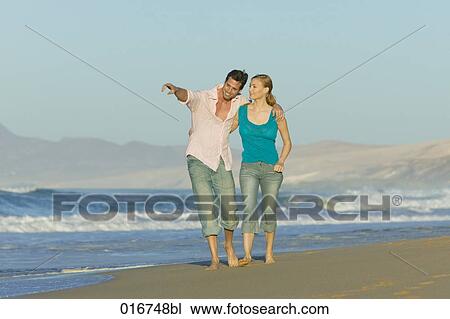 young couple walking along beach together View Large Photo Image Stock Image - young couple walking along beach together. Fotosearch