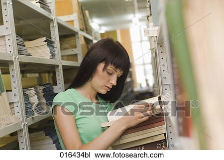 young female student reading book in school library View Large Photo Image Stock Image - young female student reading book in school library. Fotosearch