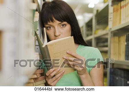 young female student reading textbook in school library View Large Photo Image Stock Image - young female student reading textbook in school library. Fotosearch