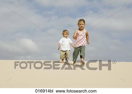 young girl and little brother walking on sandy beach View Large Photo Image Stock Image - young girl and little brother walking on sandy beach. Fotosearch