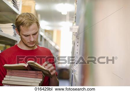 young male student reading book in school library View Large Photo Image Stock Image - young male student reading book in school library. Fotosearch